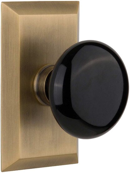 New York Rosette Door Set with Black Porcelain Knobs in Antique Brass.